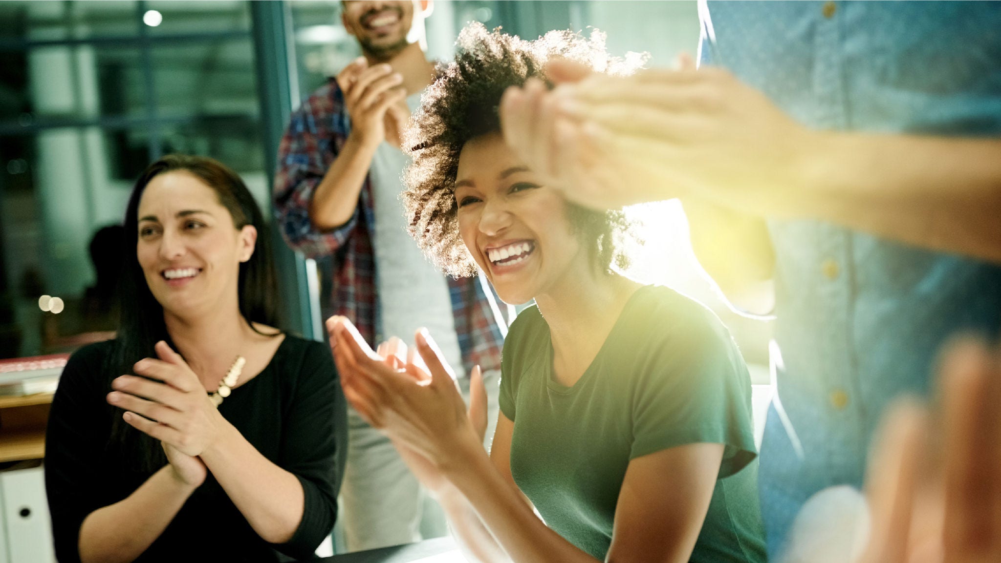 group of people clapping and smiling at the office