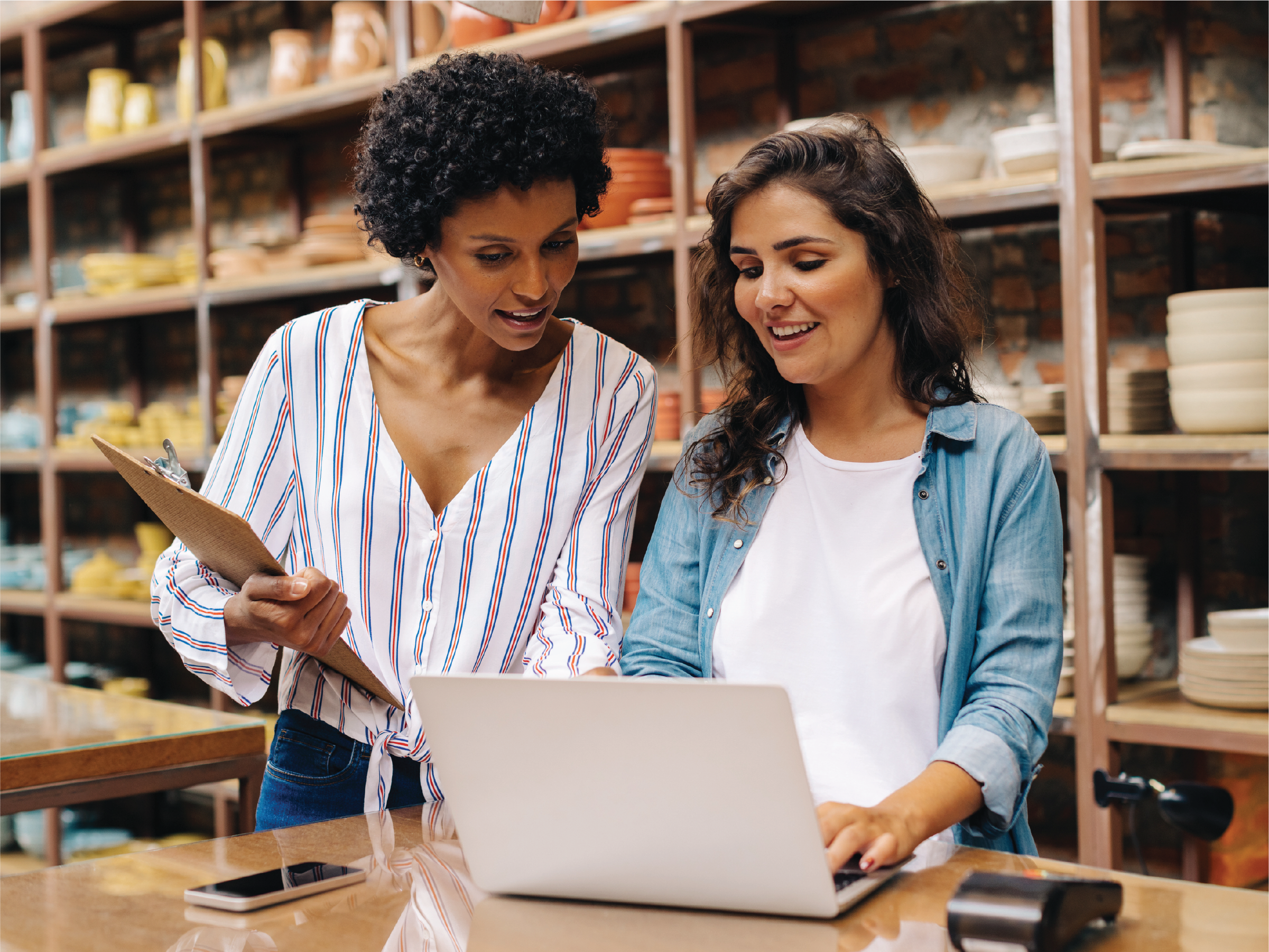 two women collaborating in front of a laptop