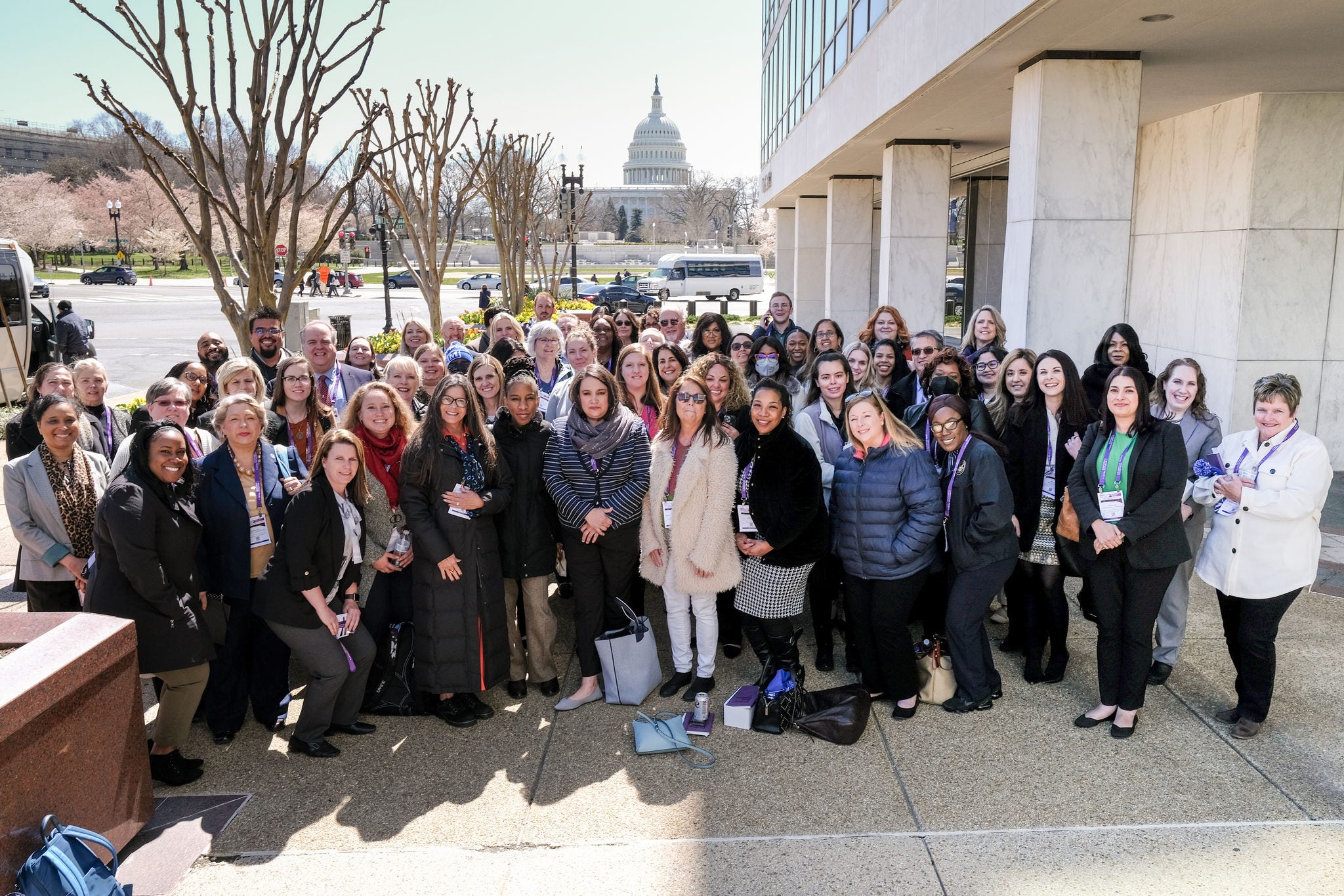 group of people posing for a photo in front of the us capitol