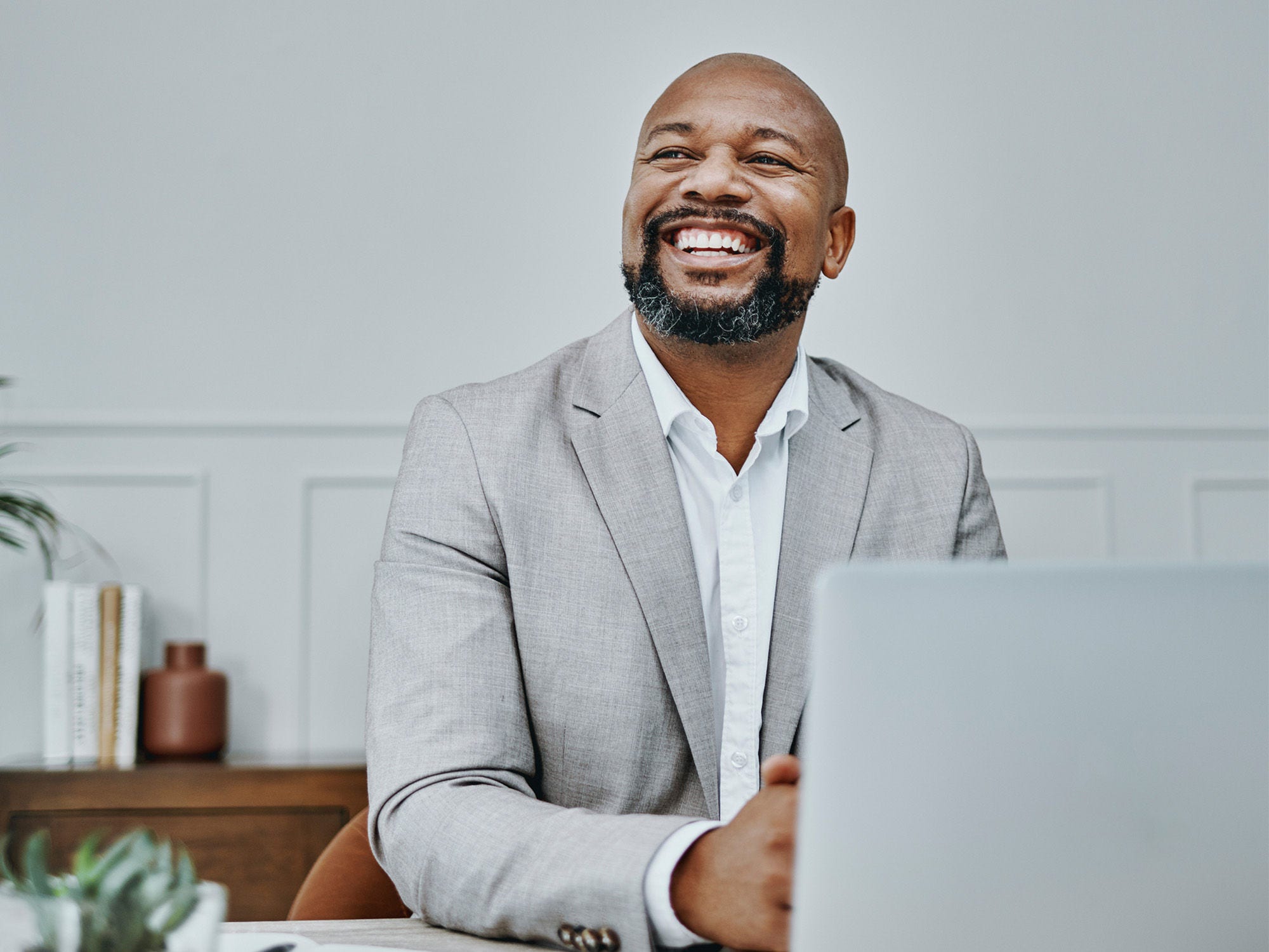 Executive laughs at his laptop.