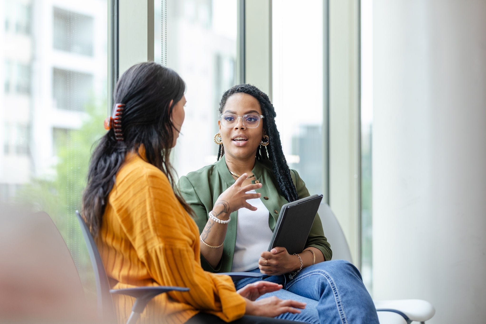 A female therapy patient listens attentively to a female therapist discuss coping strategies.