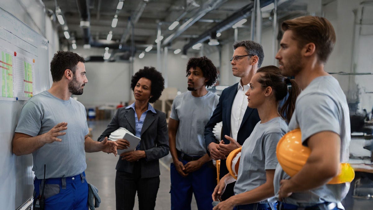 group of coworkers in a factory posing for a photo