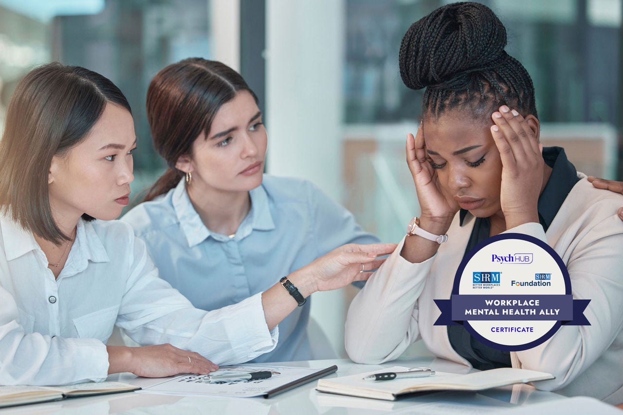 Two women consoling a distressed woman in an office setting.