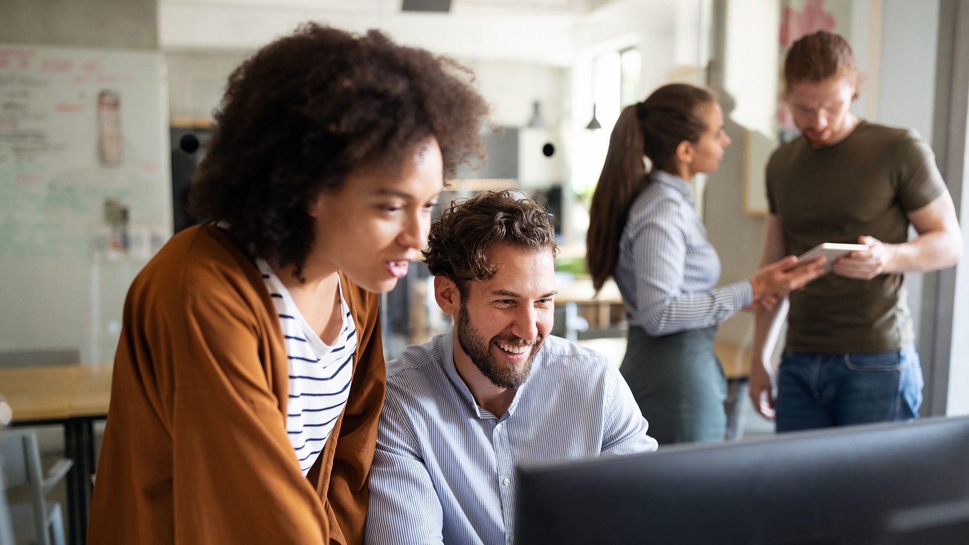 Employees collaborate over a desktop