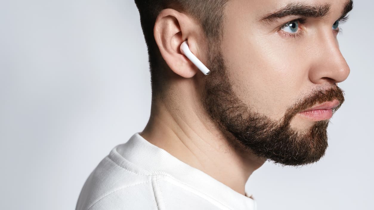A man with a beard wearing earphones.