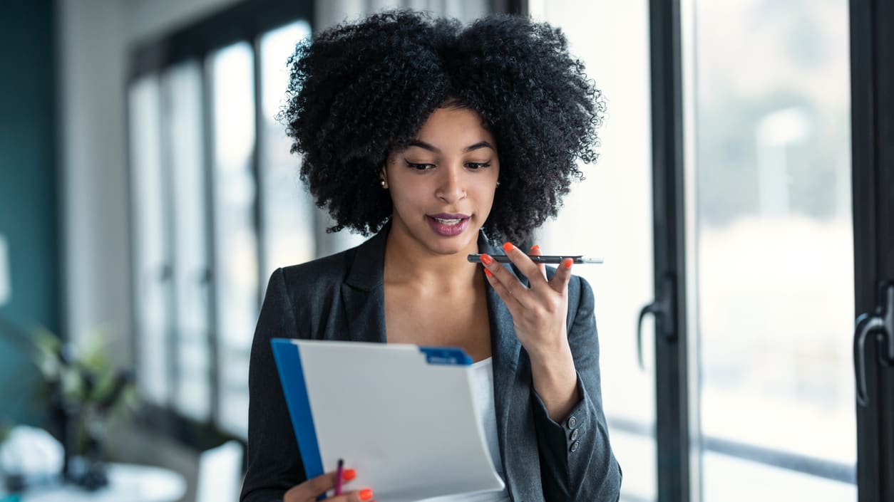 Afro-american businesswoman looking at a clipboard in an office.
