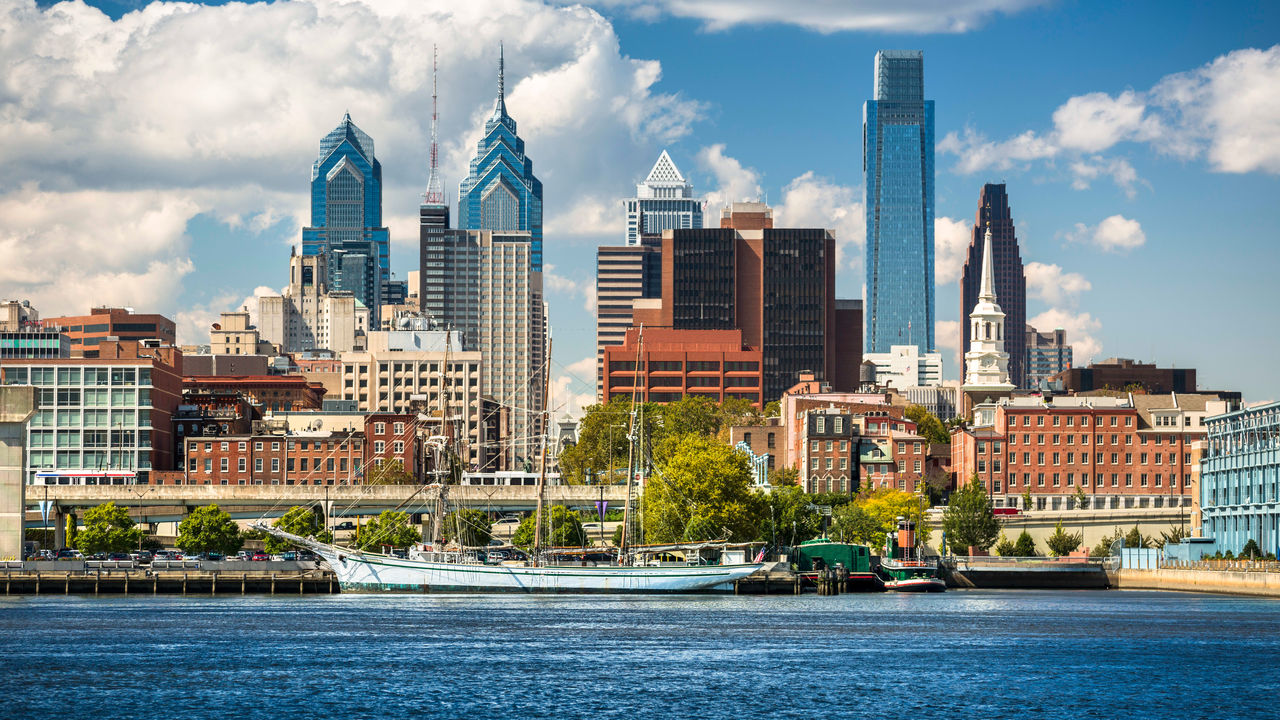 The skyline of philadelphia with a boat in the water.