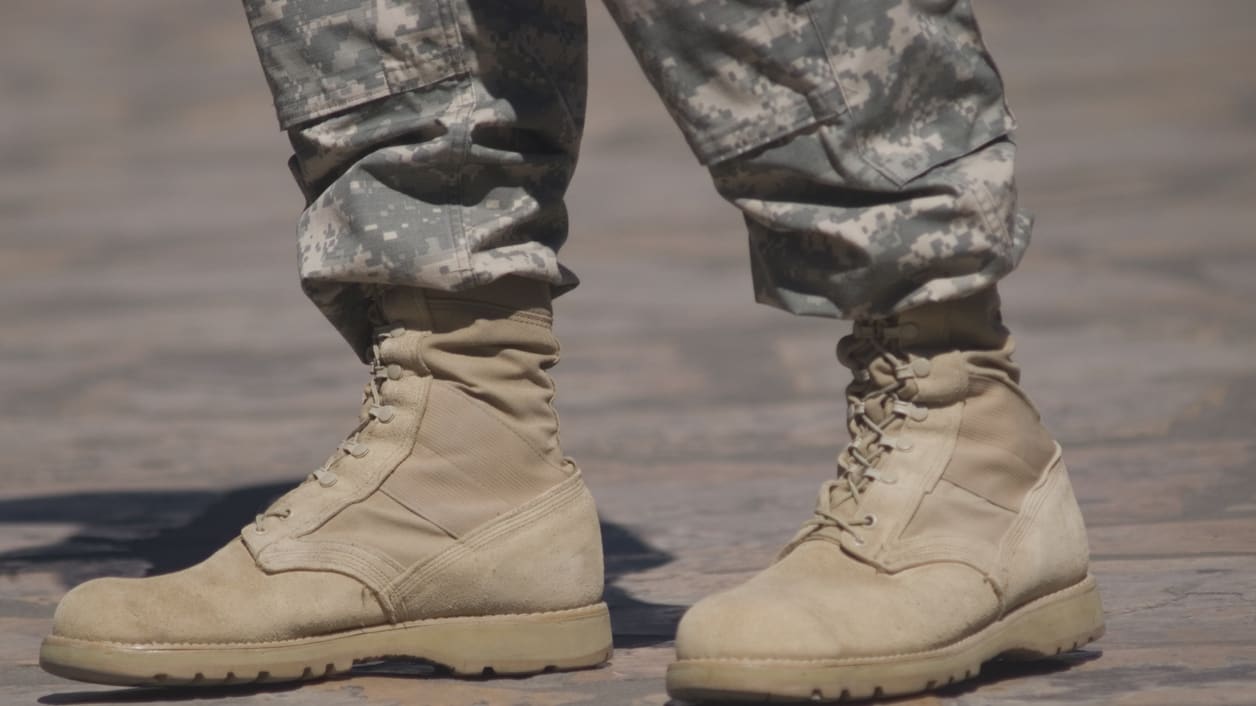 A pair of military boots standing on a street.
