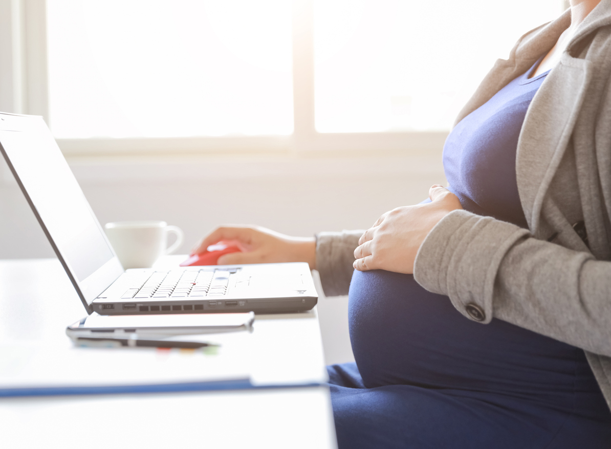 pregnant woman works at laptop