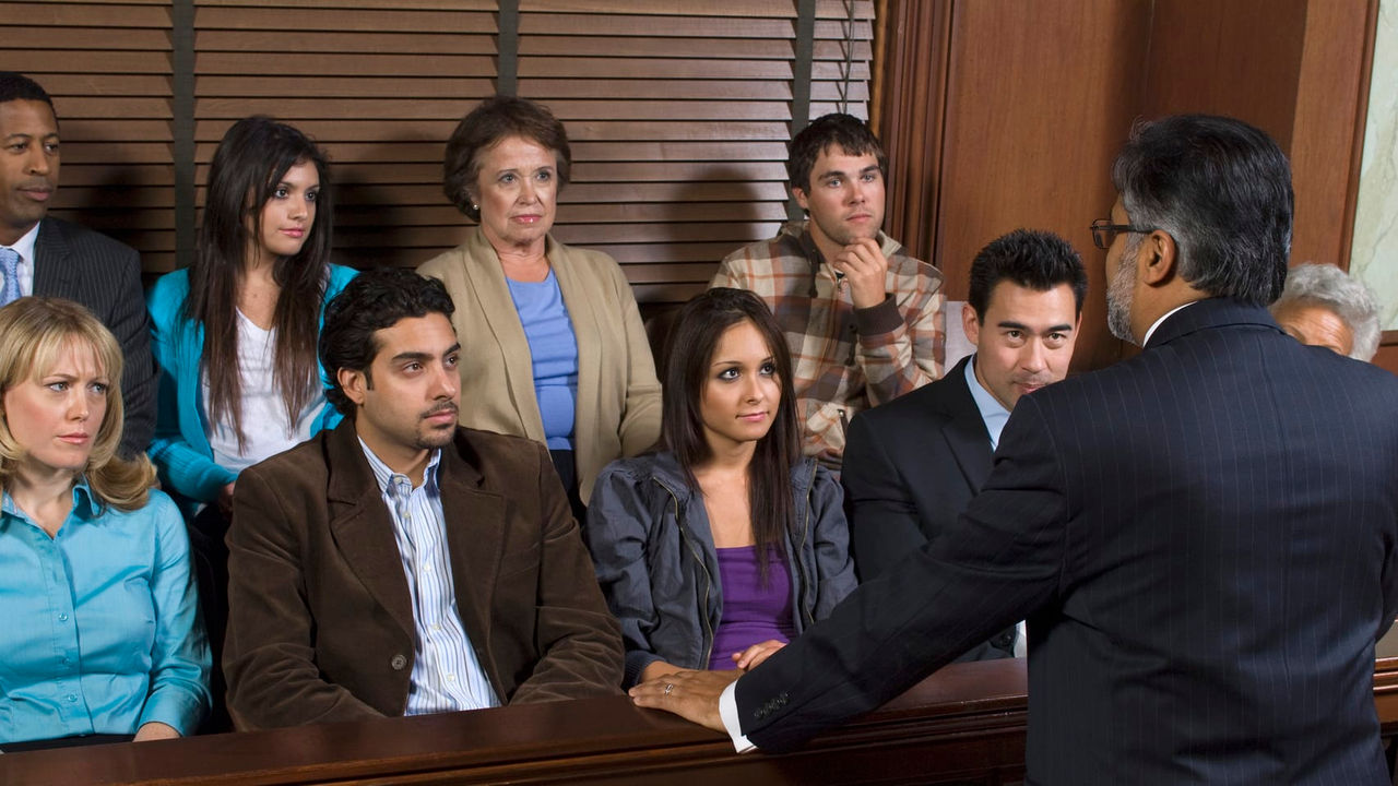 A group of people sitting in a courtroom.