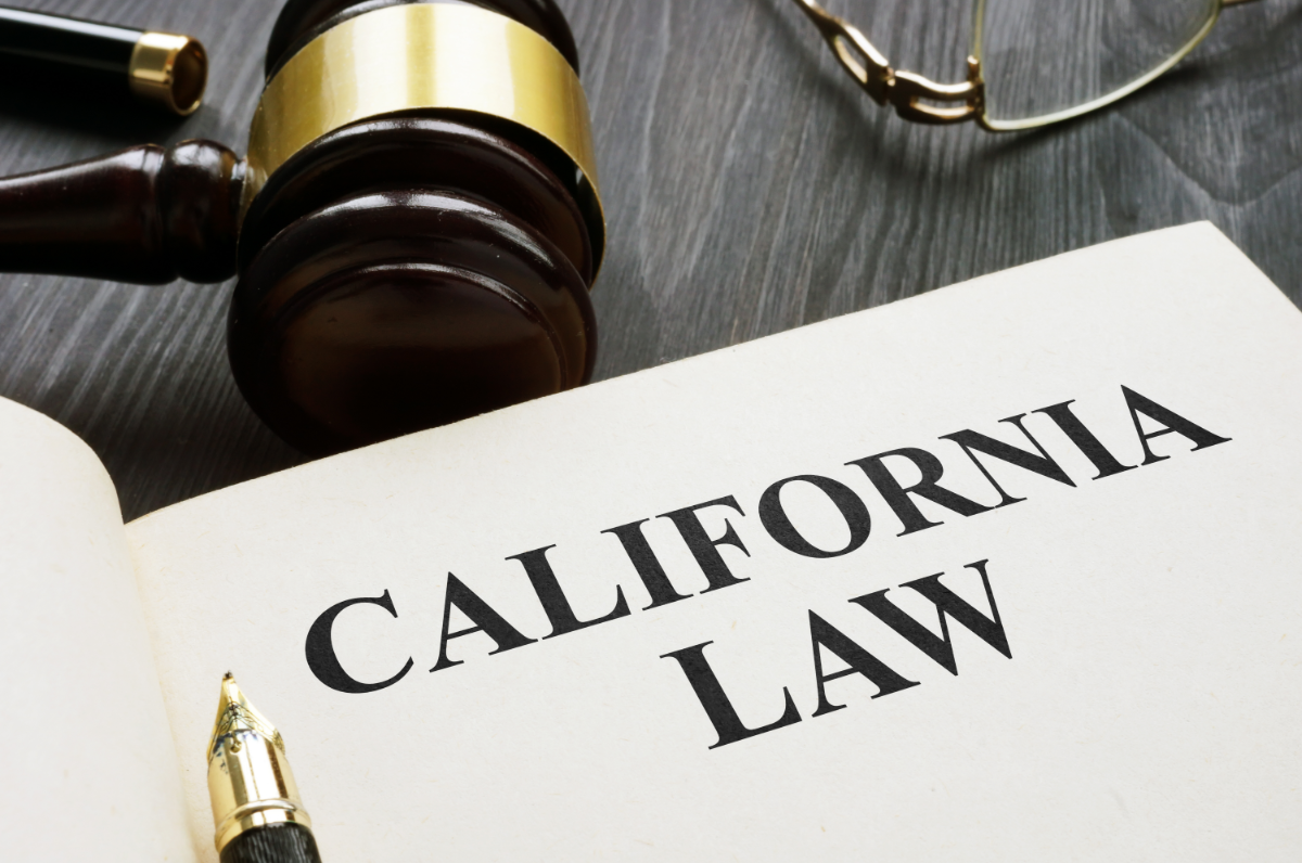 A piece of paper with California Law written on it, a pen and a gavel