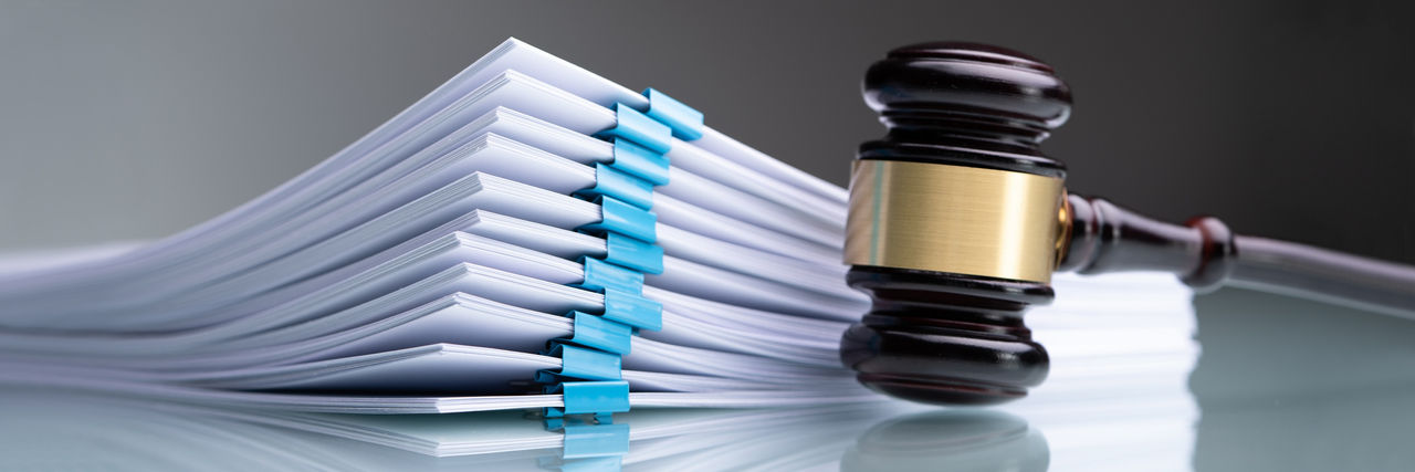 A gavel beside a stack of legal papers.