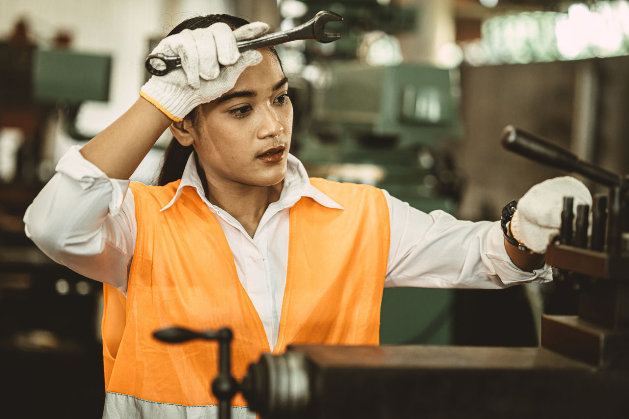 An employee working in a hot indoor manufacturing workplace with tools