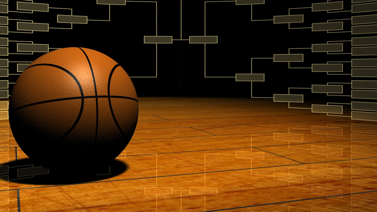 A basketball sitting on a wooden floor with brackets in the background.