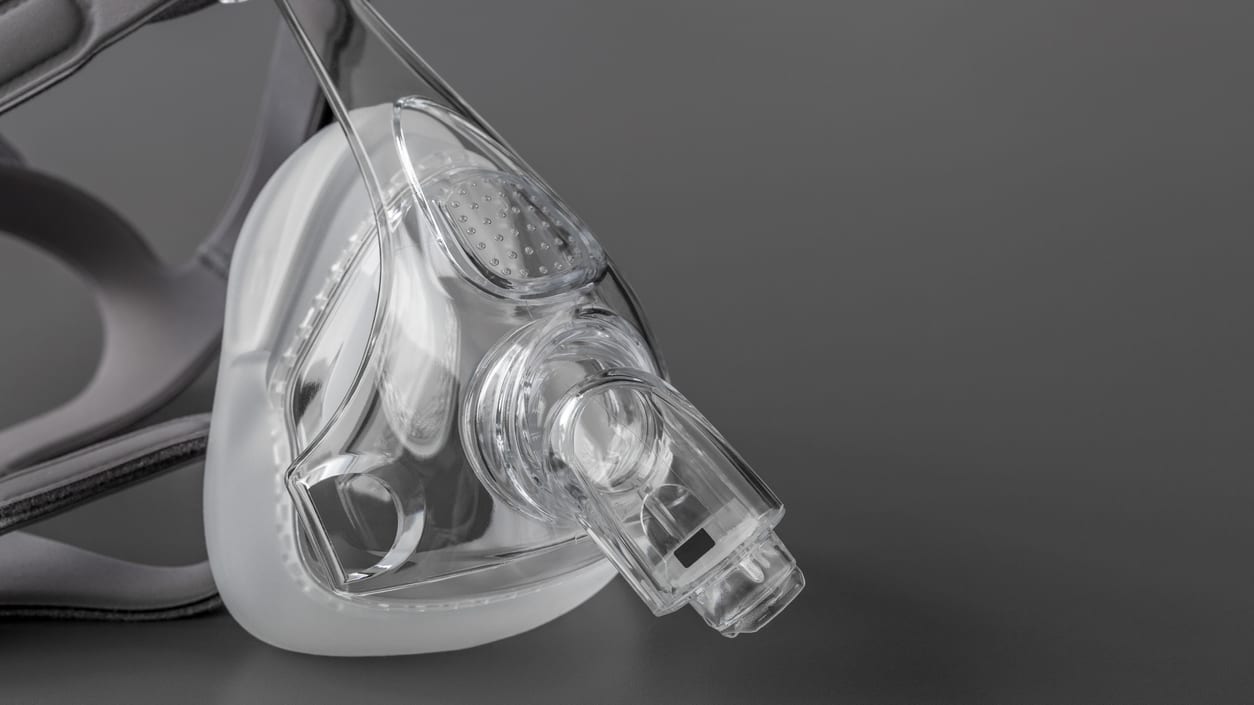 A nebulizer mask on a gray background.