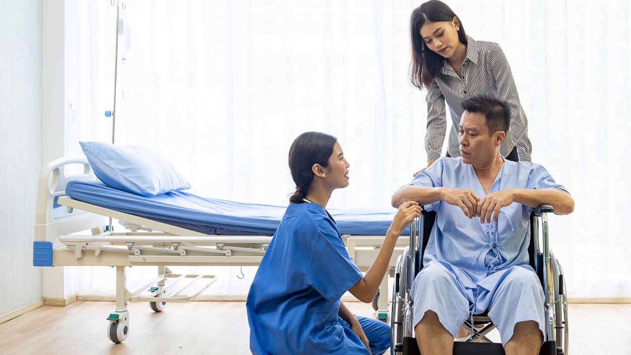 A nurse is helping a patient in a wheelchair.