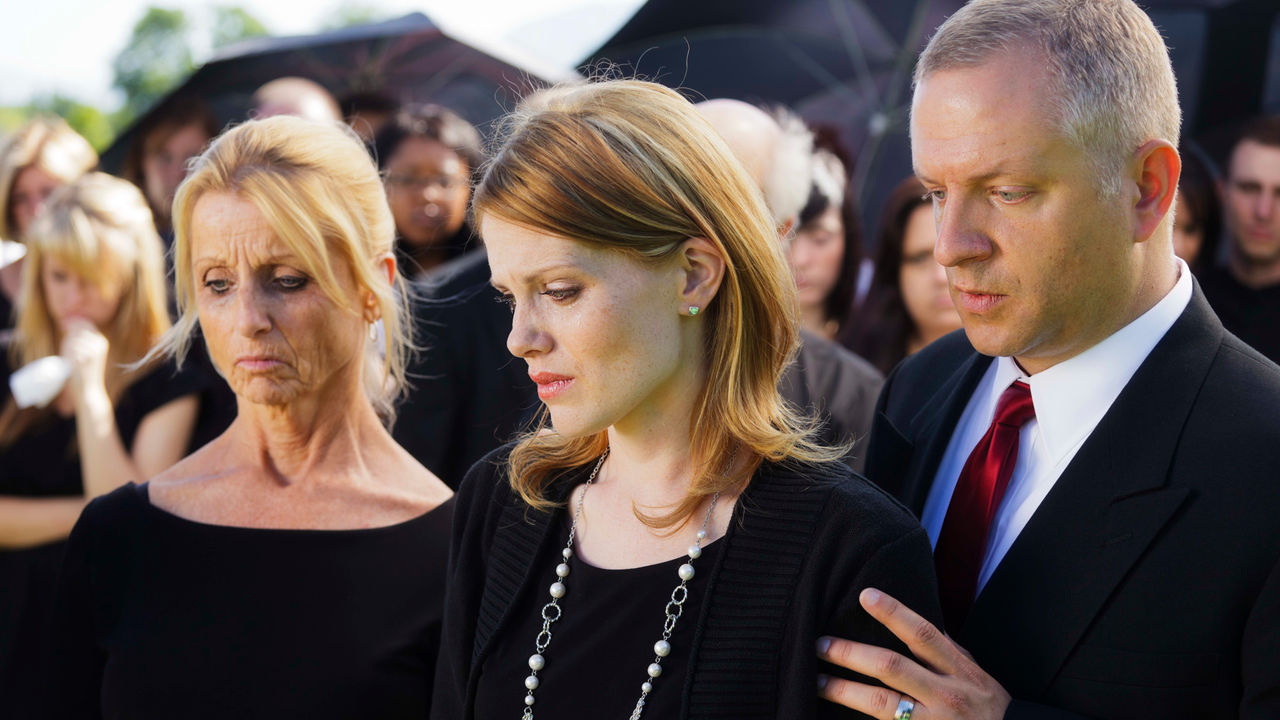 A group of people standing together at a funeral.