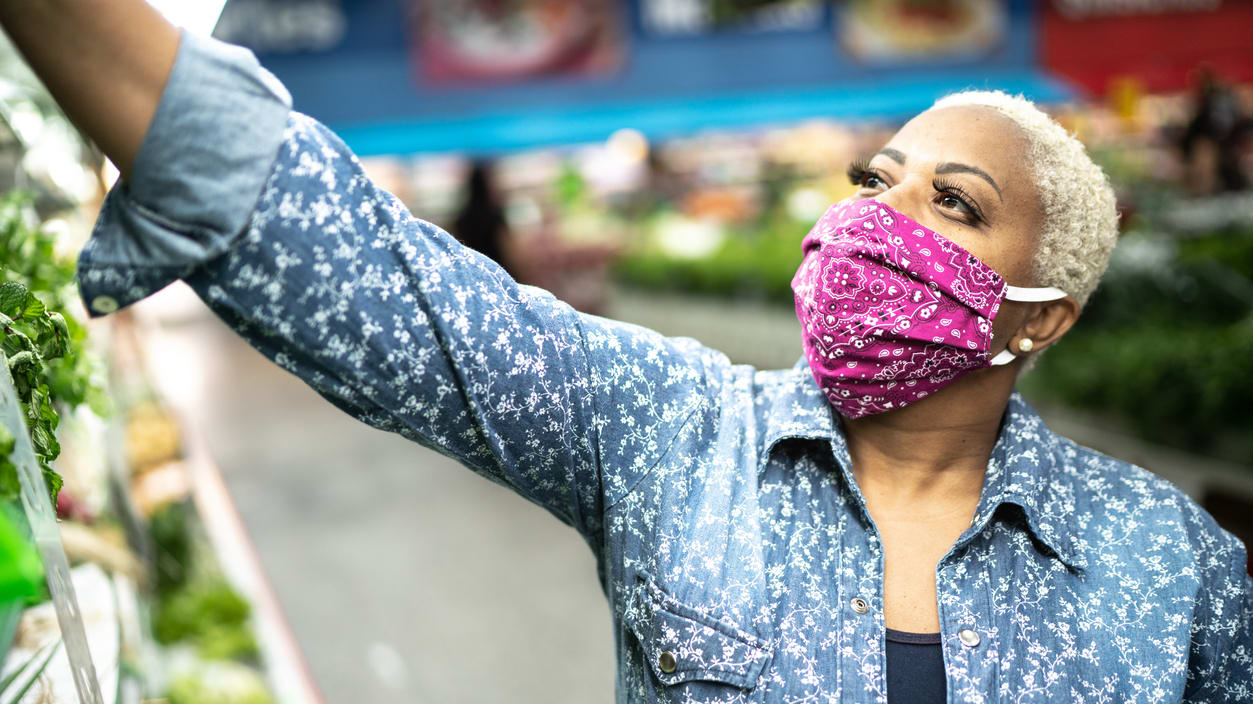 A woman wearing a face mask in a grocery store.