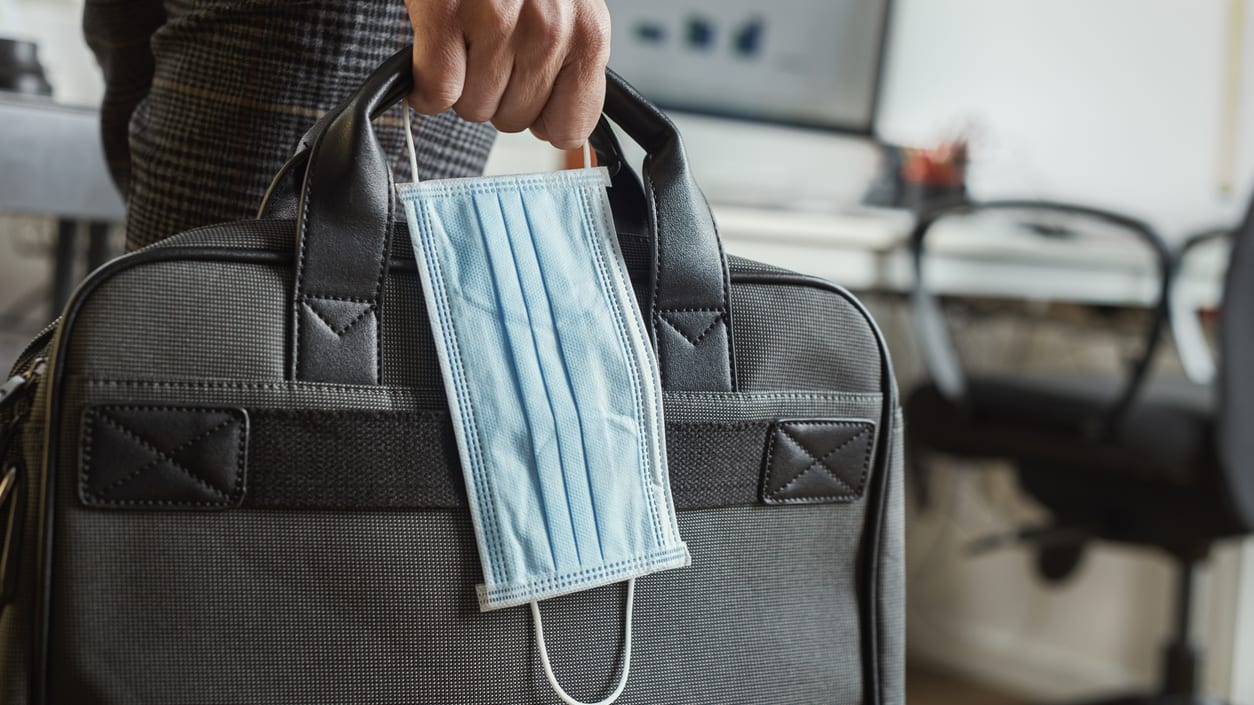 A man is carrying a medical mask in a briefcase.