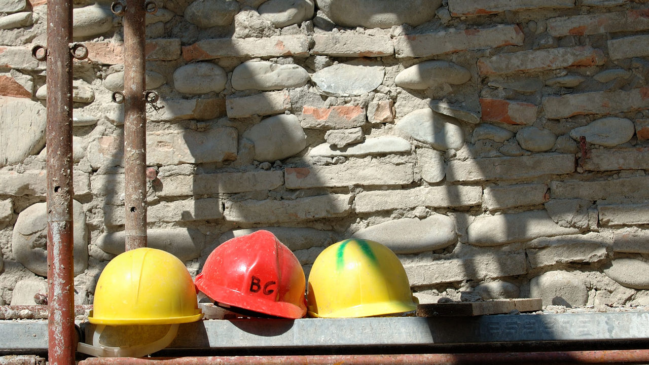 Three construction hard hats on a wall.