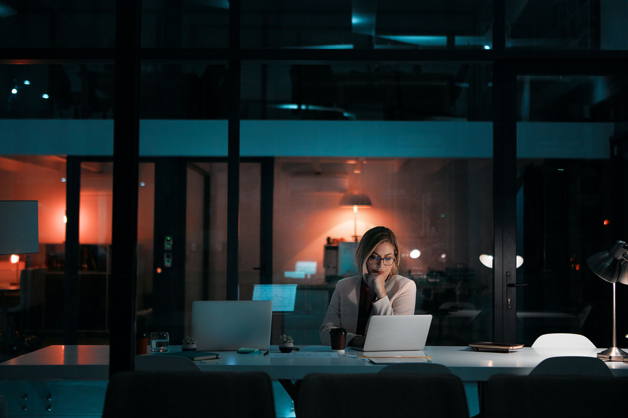 An employee working late at night at her laptop.