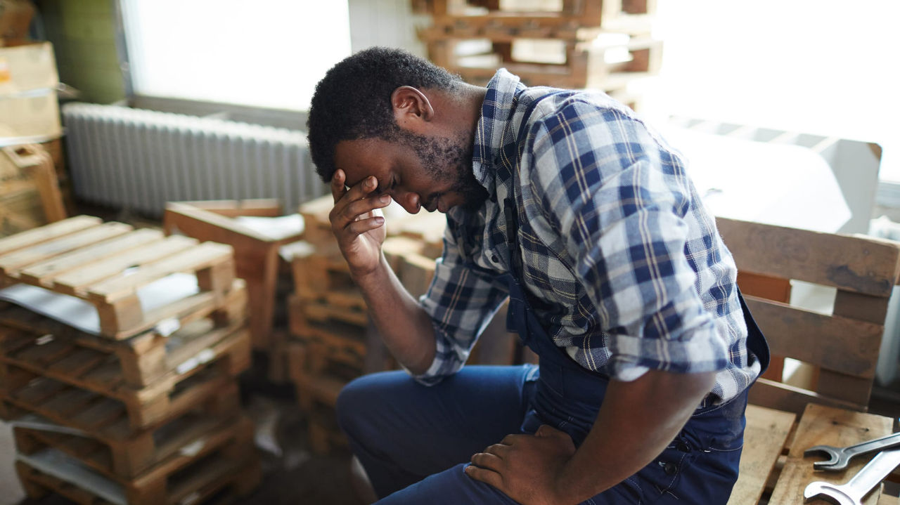 A man sitting on a pallet in a warehouse.