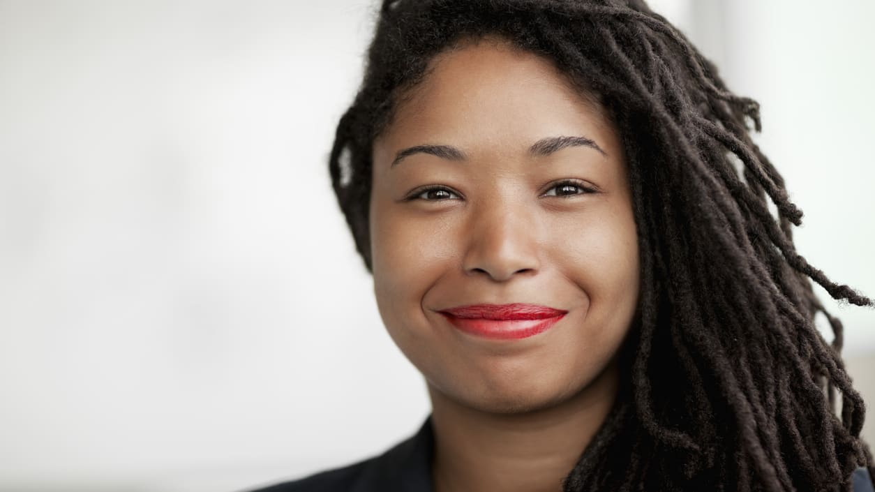 A woman with dreadlocks smiling at the camera.