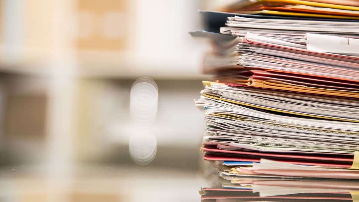 A stack of papers on a table in an office.