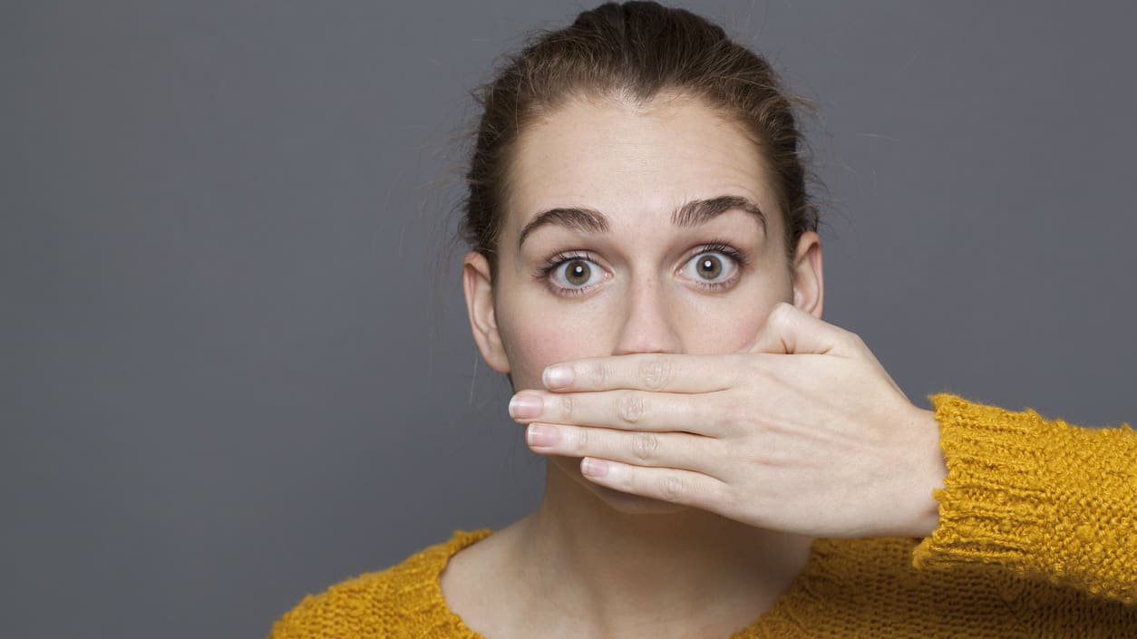 A woman covering her mouth with her hand.