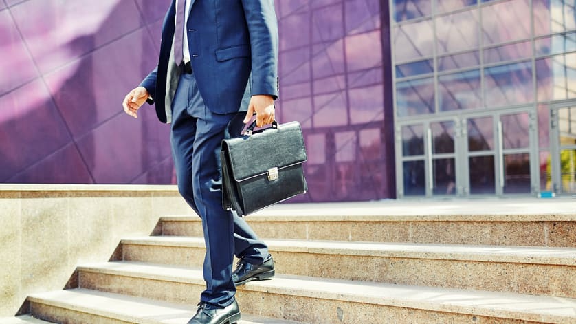 A businessman in a suit is walking down some steps.