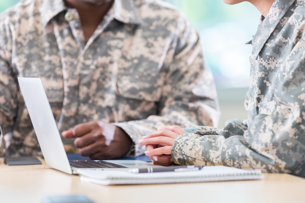 Two U.S. soldiers, one of whom is at a laptop