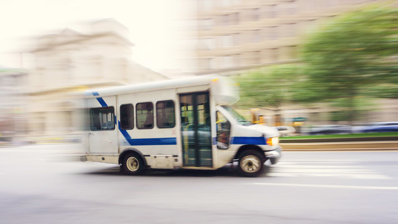 A blurry image of a bus driving down a city street.