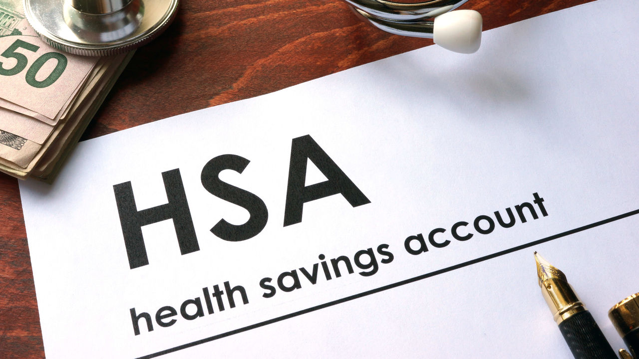 Letterhead with HSA and health savings account at the top of it, also with a pen, stethoscope and stack of $50 bills.