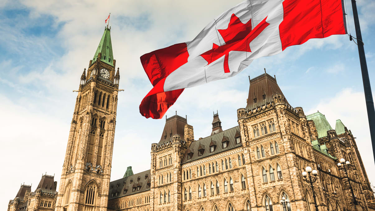 A canadian flag flying in front of a building.