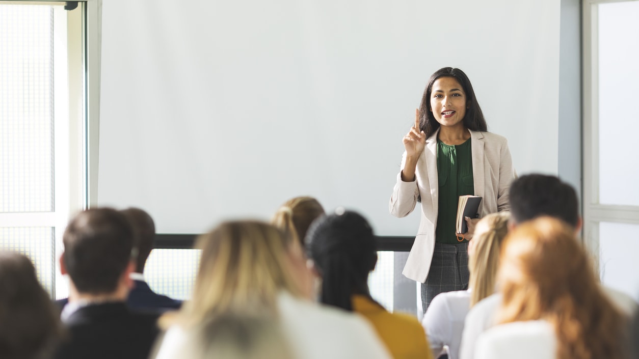 A woman giving a presentation to a group of people.