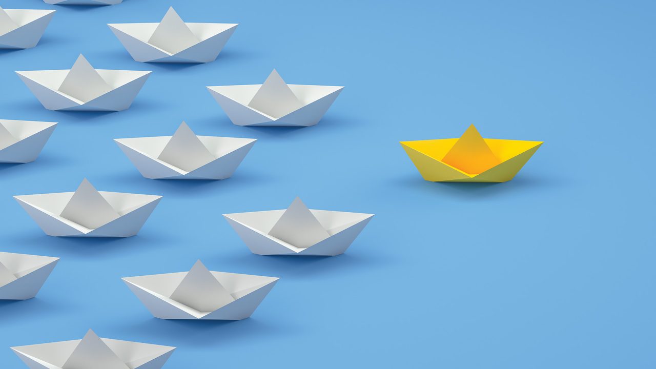 An array of paper boats following a single paper boat symbolize leadership.