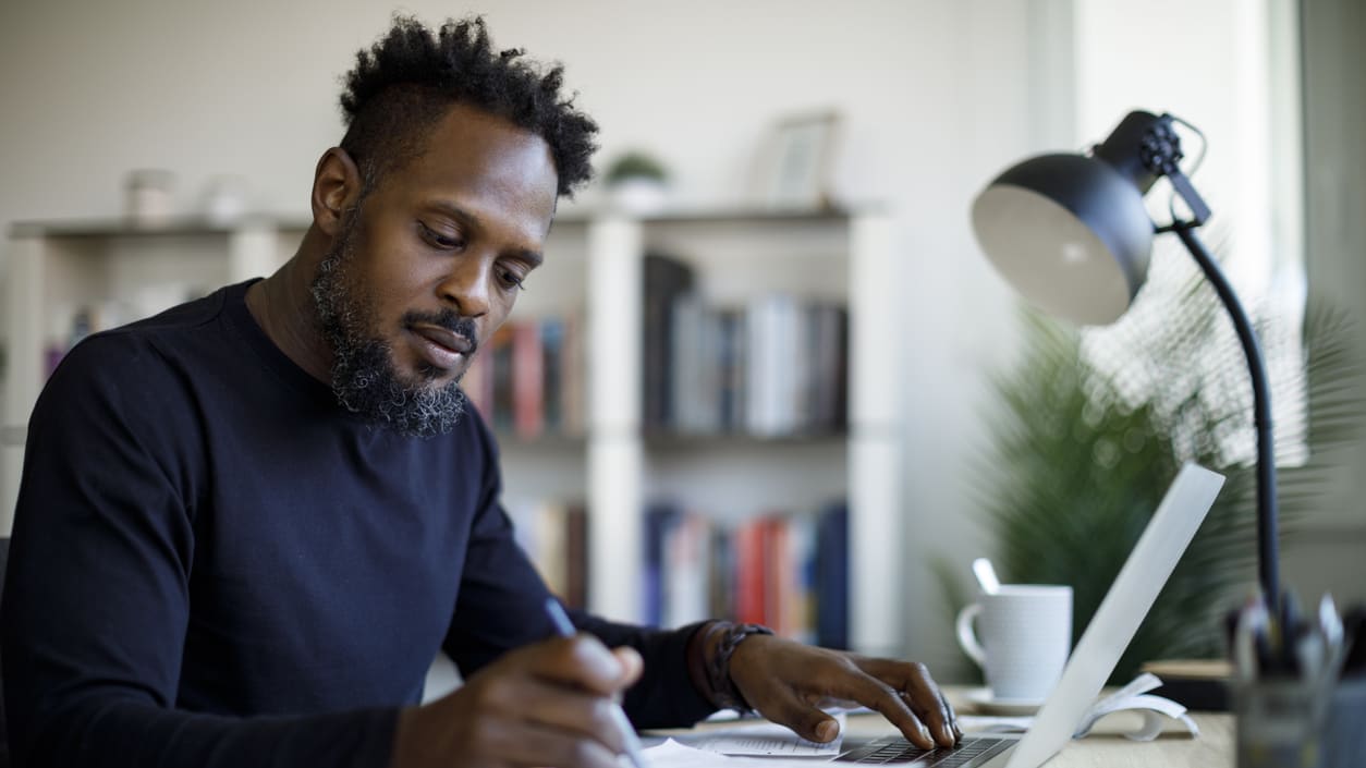 A man working on a laptop in his home office.