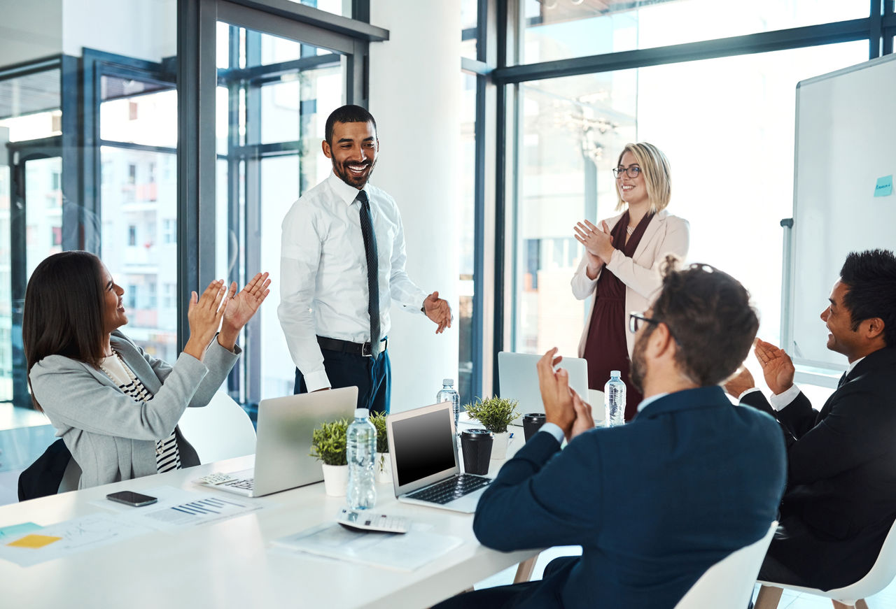 844386298 Shot of businesspeople applauding a colleague in an office