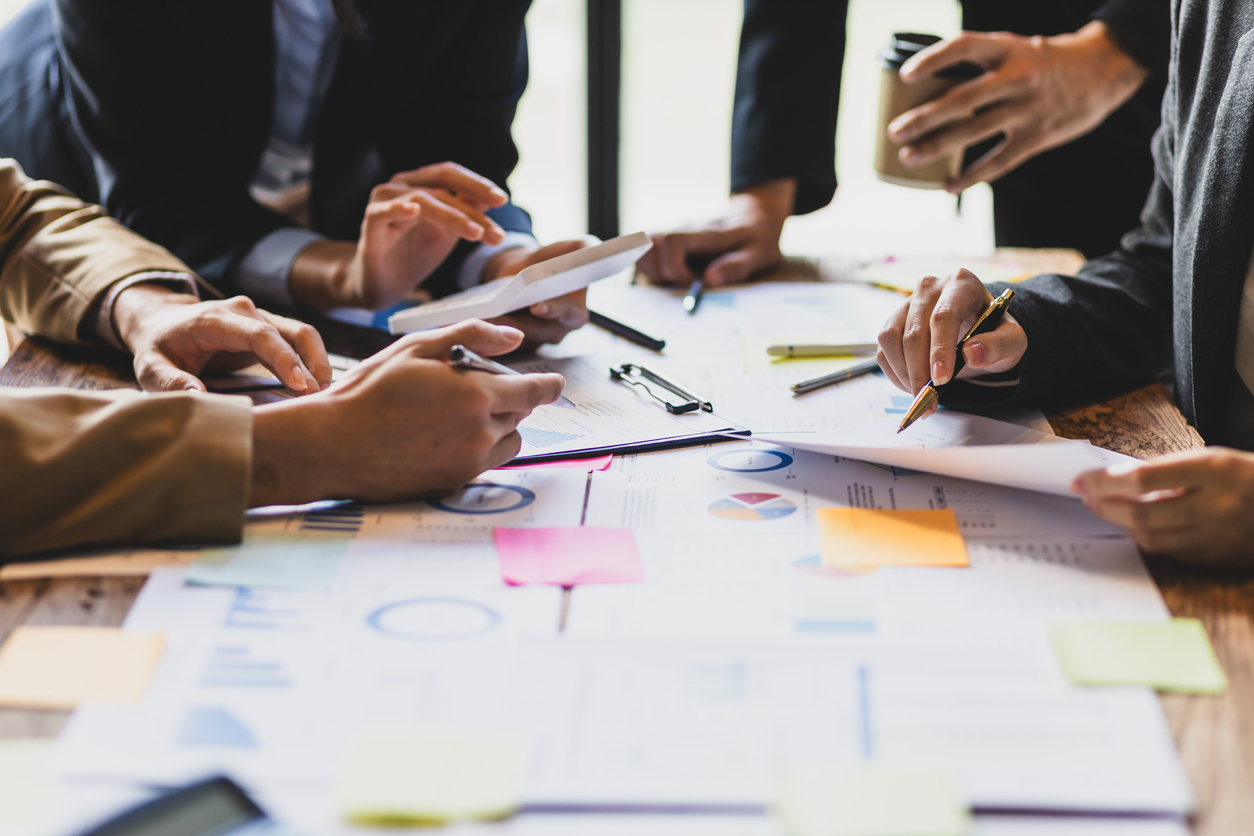 2073485467 Brainstorm business meeting to discuss analysis of financial figures, graphs and growth charts of business investments to plan new business projects.
